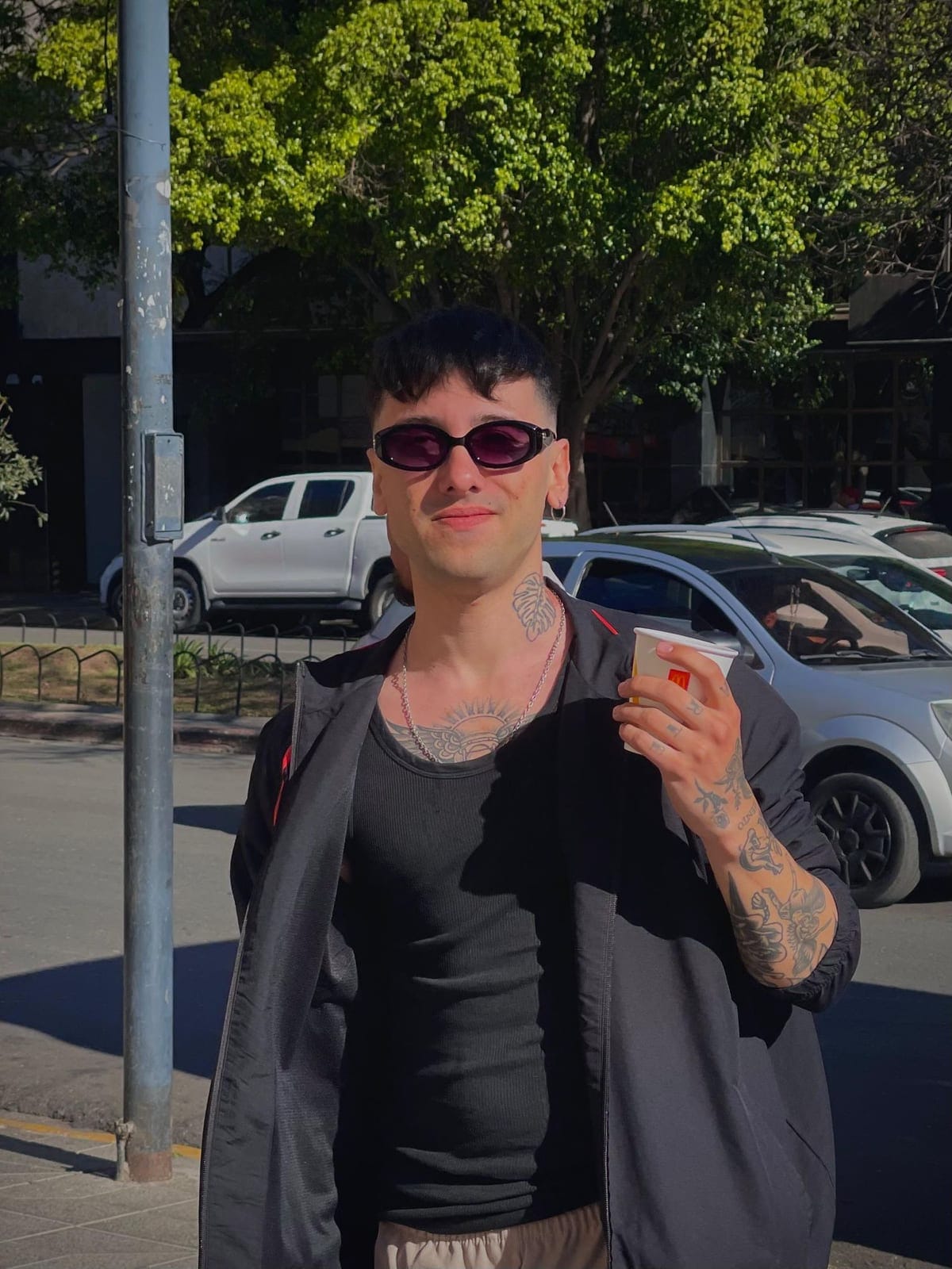 Misea con campera negra y anteojos de sol en la calle